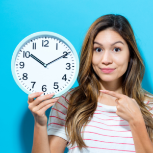 woman holding and pointing to a clock